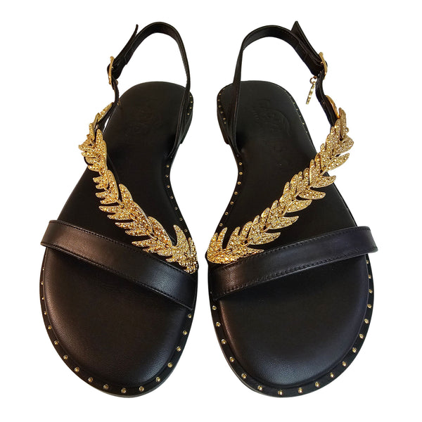Caryatis, Sandale mit goldfarbenem Zierschmuck in Schwarz