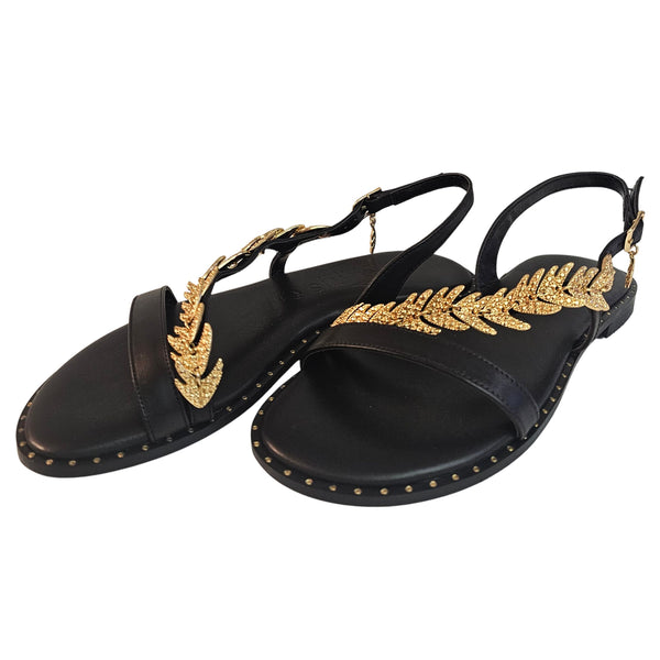 Caryatis, Sandale mit goldfarbenem Zierschmuck in Schwarz